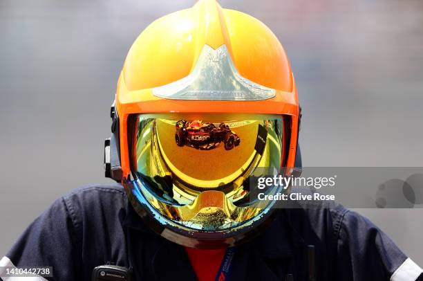 Max Verstappen of the Netherlands driving the Oracle Red Bull Racing RB18 is reflected in the helmet of a track fire fighter during final practice...