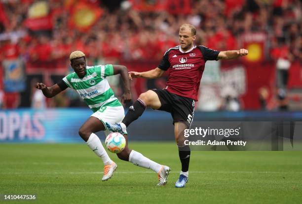 Johannes Geis of 1. FC Nuernberg is challenged by Ragnar Ache of SpVgg Greuther Fuerth during the Second Bundesliga match between 1. FC Nürnberg and...