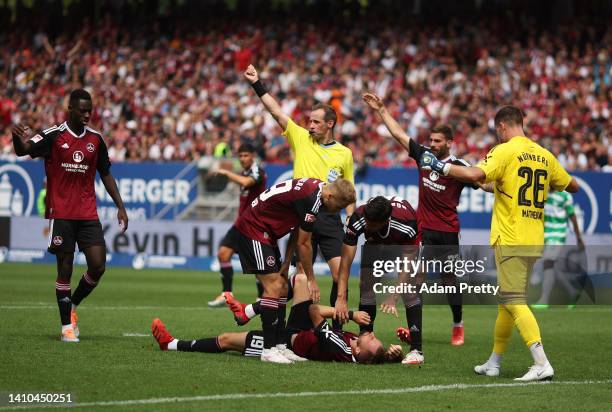 Florian Huebner of 1. FC Nuernberg is injured after a head clash during the Second Bundesliga match between 1. FC Nürnberg and SpVgg Greuther Fürth...