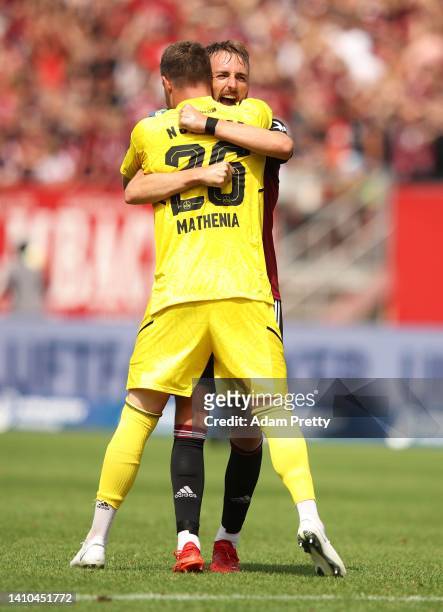 Florian Huebner of 1. FC Nuernberg celebrates with goalkeeper Christian Mathenia of 1. FC Nuernberg after victory in the Second Bundesliga match...