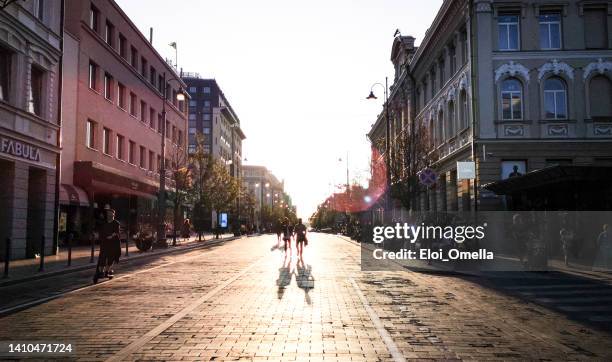 silhouette of people at gedimino pr street in vilnius at sunset - vilnius street stock pictures, royalty-free photos & images