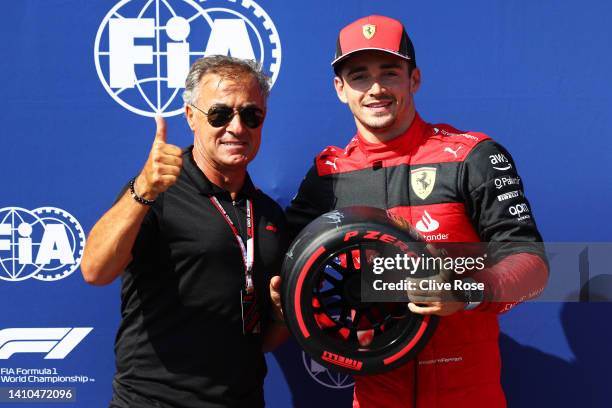 Pole position qualifier Charles Leclerc of Monaco and Ferrari is presented with the Pirelli Pole Position trophy by Jean Alesi in parc ferme during...