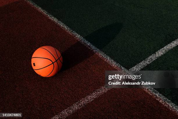 outdoor basketball court in the courtyard. a basketball is lying on the ground, a sports field, on a sunny summer day. the concept of sports and a healthy lifestyle. space for copying. - courtyard stockfoto's en -beelden