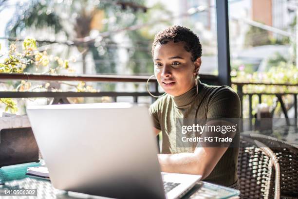 young woman using the laptop in a restaurant - live event business stock pictures, royalty-free photos & images