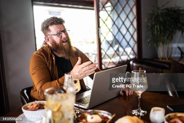reifer mann im gespräch mit kollege in einem restaurant - business talk sit men stock-fotos und bilder