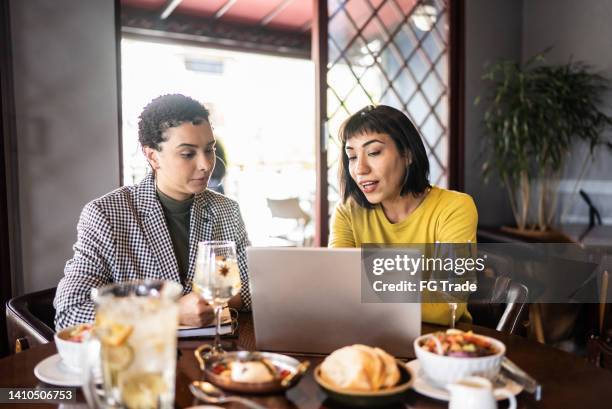 coworkers doing a meeting and having a drink in a restaurant - virtual lunch stock pictures, royalty-free photos & images