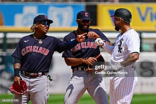 Jose Ramirez and Amed Rosario of the Cleveland Guardians joke around with Yoan Moncada of the Chicago White Sox at second base during a pitching...