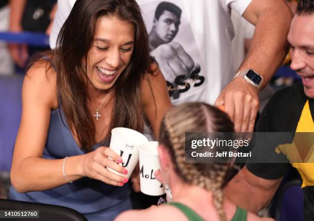 Molly McCann of England shares a celebratory drink with Joanna Jedrzejczyk and Michael Chandler after her knockout victory over Hannah Goldy in a...