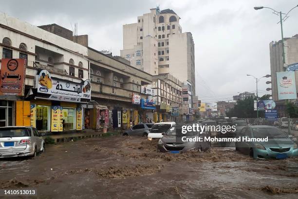 People drive in a flooded street following heavy rains on July 23, 2022 in Sana'a, Yemen.