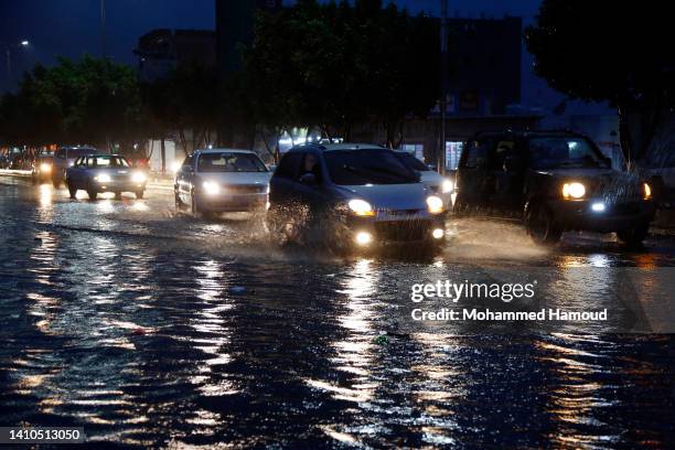 People drive in a flooded street following heavy rains on July 23, 2022 in Sana'a, Yemen.