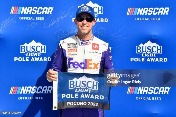 Denny Hamlin, driver of the FedEx Office Toyota, poses for photos after winning the pole award during qualifying for the NASCAR Cup Series M&M's Fan...