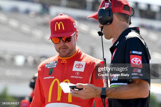 Kurt Busch, driver of the McDonald's Toyota, works with a crew member during qualifying for the NASCAR Cup Series M&M's Fan Appreciation 400 at...