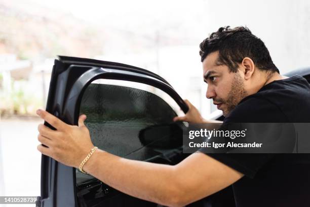 worker applying car window film - filtration membrane stock pictures, royalty-free photos & images
