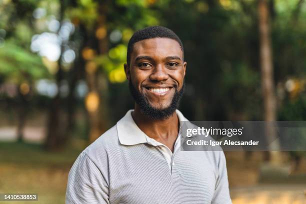 young man in the public park - smiling stockfoto's en -beelden