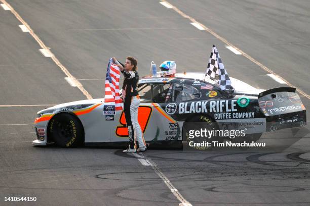 Noah Gragson, driver of the Bass Pro Shops/TrueTimber/BRCC Chevrolet, celebrates with the American flag after winning the NASCAR Xfinity Series...