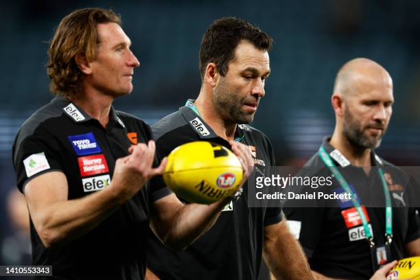 Giants assistant coaches James Hird and Dean Solomon speak with Giants interim coach Mark McVeigh before the round 19 AFL match between the Carlton...