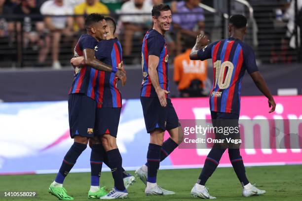 Raphael Dias of Barcelona celebrates with his teammates after scoring their first goal during the preseason friendly match between Real Madrid and...
