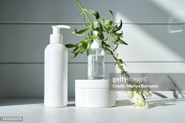 skin care products on a chest of drawers against a white wooden wall. - blank packaging stock-fotos und bilder