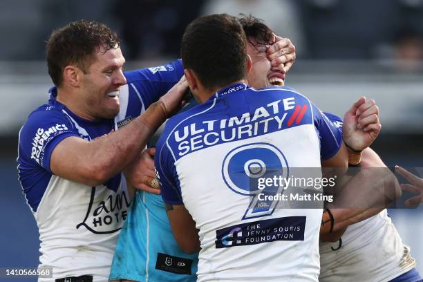 Corey Waddell of the Bulldogs tackles Tino Fa'asuamaleaui of the Titans with his hands on his eyes during the round 19 NRL match between the...