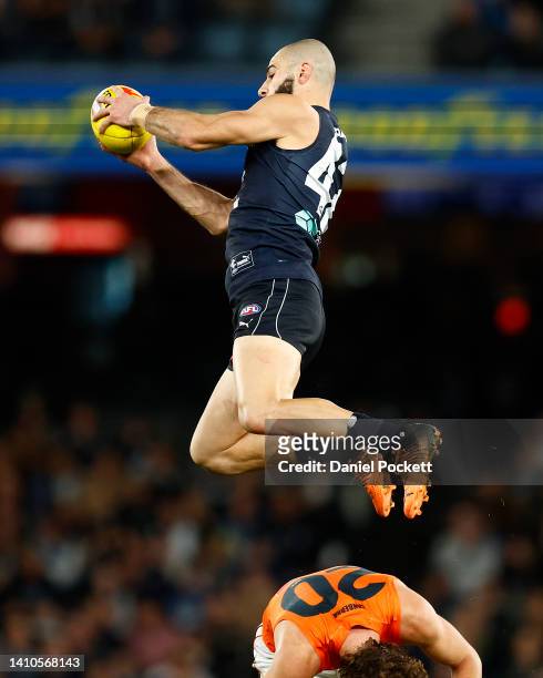 Adam Saad of the Blues takes a high mark over James Peatling of the Giants during the round 19 AFL match between the Carlton Blues and the Greater...