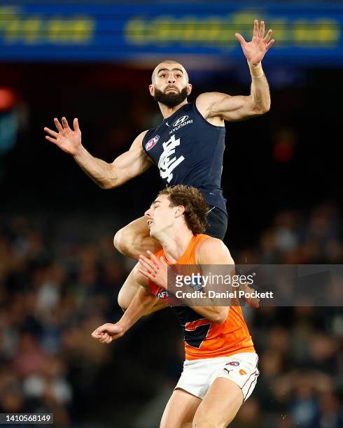 Adam Saad of the Blues takes a high mark over James Peatling of the Giants during the round 19 AFL match between the Carlton Blues and the Greater...
