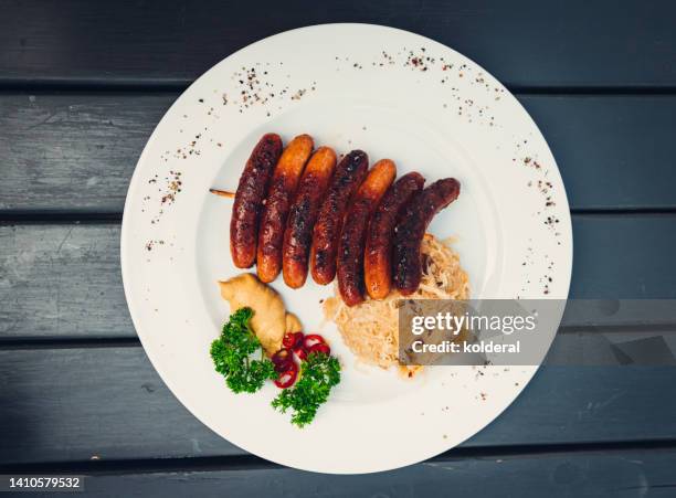 traditional german grilled sausages with cabbage on white plate - duitse gerechten stockfoto's en -beelden