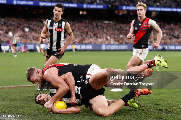 Jake Stringer of the Bombers tackles Scott Pendlebury of the Magpies during the round 19 AFL match between the Collingwood Magpies and the Essendon...