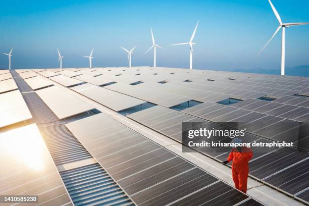 solar panels and wind turbins ,concept of sustainable resources,engineer working on checking and maintenance electrical equipment - indagini di clima foto e immagini stock