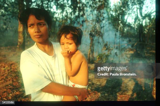 Family members try to stop a fire from burning their house March 16, 1998 near Balikpapan, Indonesia. The arrival of an early dry season has resulted...