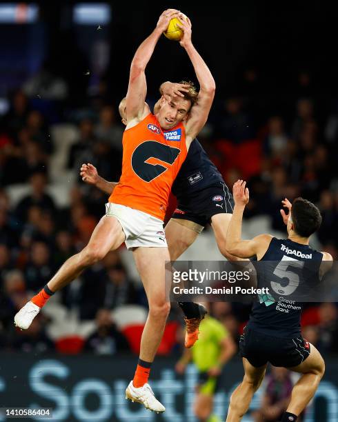 Lachlan Keeffe of the Giants marks the ball against Adam Saad of the Blues during the round 19 AFL match between the Carlton Blues and the Greater...