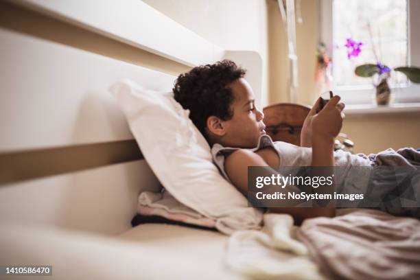 little boy playing online games on mobile phone - game six stockfoto's en -beelden