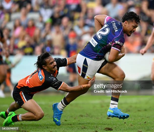 Jeremiah Nanai of the Cowboys attempts to break the tackle of Daine Laurie of the Tigers during the round 19 NRL match between the North Queensland...