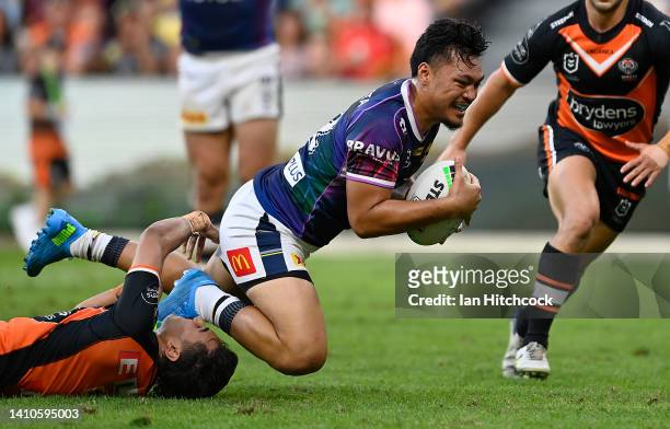 Jeremiah Nanai of the Cowboys is tackled by Daine Laurie of the Tigers during the round 19 NRL match between the North Queensland Cowboys and the...