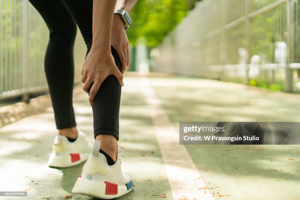 Shot of a woman massaging an injury in her leg