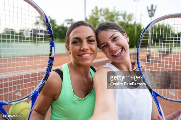 pov von tennisspielerinnen, die selfies auf dem tennisplatz machen - doubles tennis stock-fotos und bilder