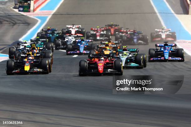 Charles Leclerc of Monaco driving the Ferrari F1-75 leads Max Verstappen of the Netherlands driving the Oracle Red Bull Racing RB18 and the rest of...