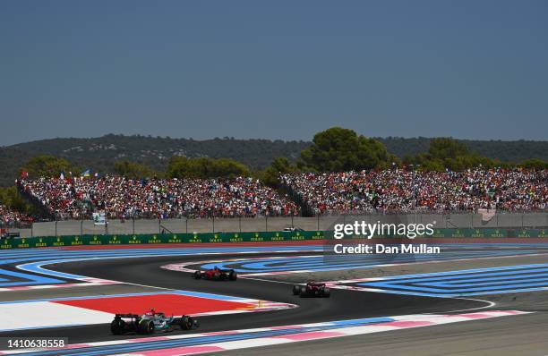 Charles Leclerc of Monaco driving the Ferrari F1-75 leads Max Verstappen of the Netherlands driving the Oracle Red Bull Racing RB18 and Lewis...