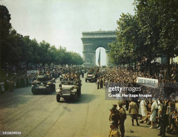 Crowds of French patriots line the Champs Elysees to view Allied tanks and half tracks pass through the Arc du Triomphe, after Paris was liberated on...