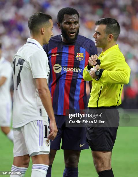 Lucas Vázquez of Real Madrid and Franck Kessie of Barcelona talk with referee Mark Allatin after he gave Vázquez a yellow card during their preseason...