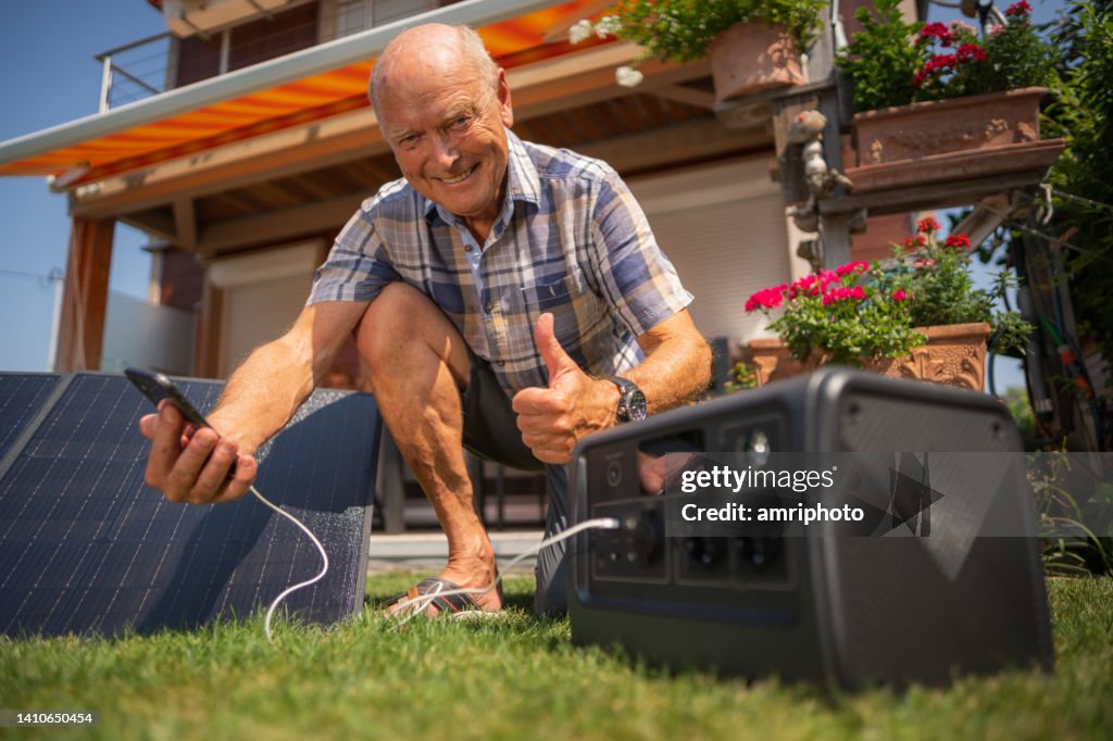 Hombre senior satisfecho con su nueva planta solar móvil