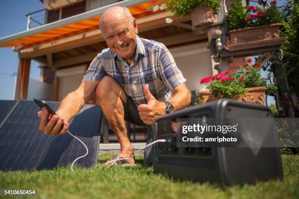 hombre senior satisfecho con su nueva planta solar móvil - suministro de energía fotografías e imágenes de stock