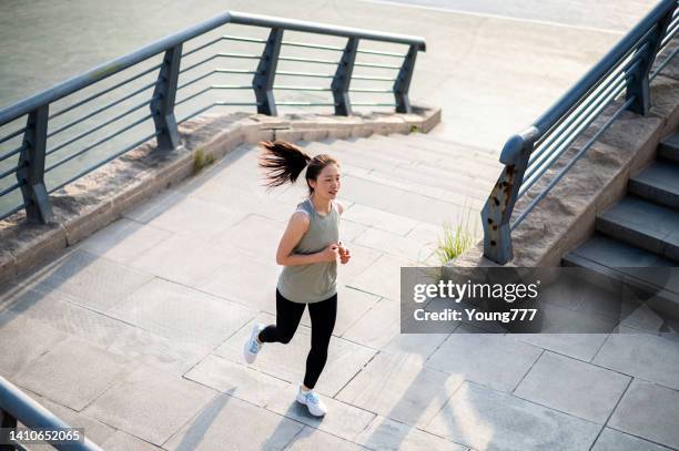 asian young woman running in the city street in the morning - china athlete woman stock pictures, royalty-free photos & images