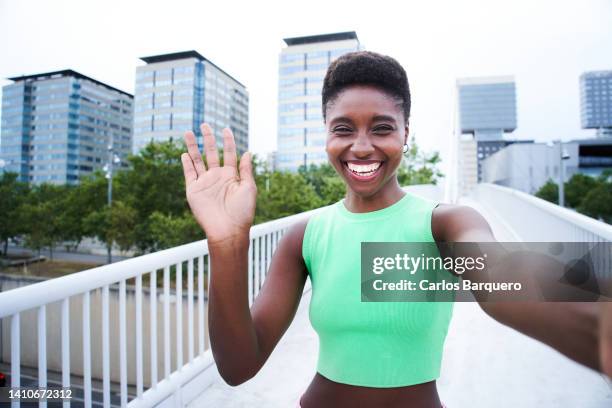 portrait of a happy black woman no a video call. - waving stock-fotos und bilder