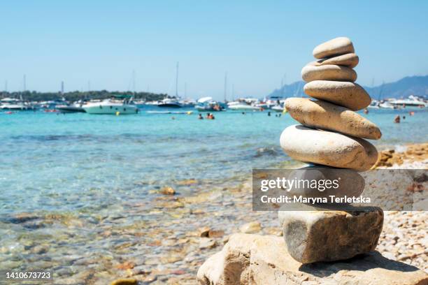 a stack of pebbles against the backdrop of the blue sea. natural background from pebbles in the sea. pebbles of different sizes and different colors. vacation. relaxation. summer. - alpes maritimes - fotografias e filmes do acervo