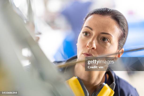 concerned female aviation mechanic face close view - vliegtuigmonteur stockfoto's en -beelden