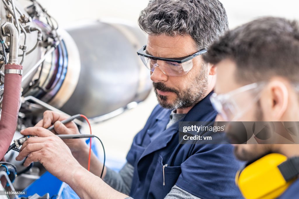 Mécaniciens d’aviation examinant le moteur, gros plan