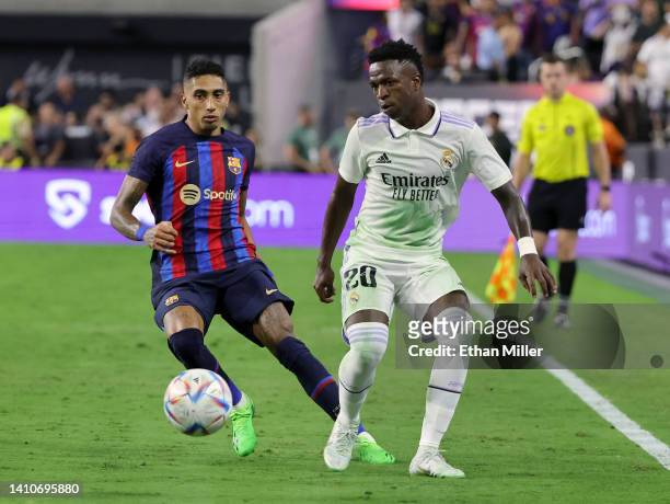 Vinícius Júnior of Real Madrid passes under pressure from Raphael “Raphinha” Dias Belloli of Barcelona during their preseason friendly match at...