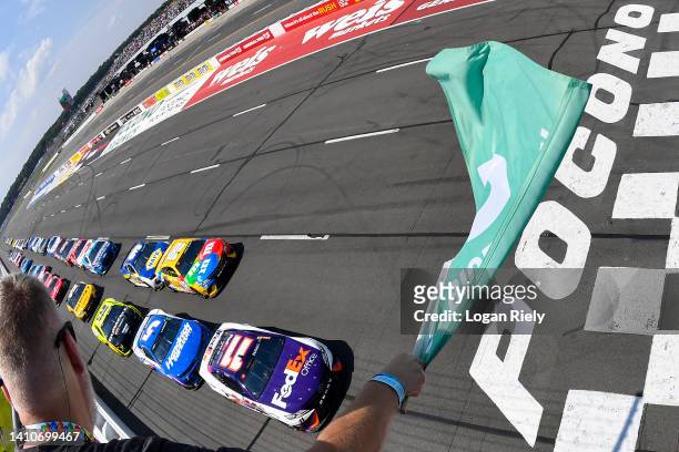 Denny Hamlin, driver of the FedEx Office Toyota, leads the field to the green flag to start the NASCAR Cup Series M&M's Fan Appreciation 400 at...