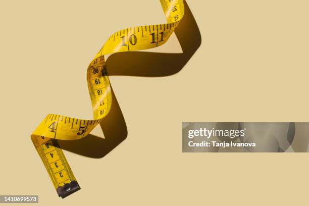 measuring tapes on beige background - metro unidad de medida fotografías e imágenes de stock