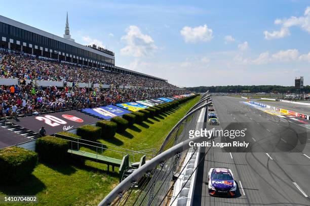 Denny Hamlin, driver of the FedEx Office Toyota, leads the field during the NASCAR Cup Series M&M's Fan Appreciation 400 at Pocono Raceway on July...